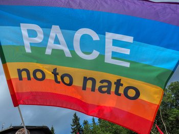 Regenbogenfahne mmit der Aufschrift:„Pace - no to Nato“