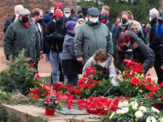 Genossinnen legen die Blumengestätte an der Gedenkstätte für unsere beiden Parteien nieder