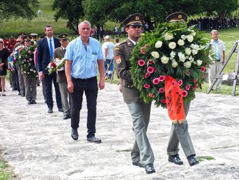 Zwei Soldaten tragen den Kranz der LINKEN. Chemnitz begleitet von Genossen