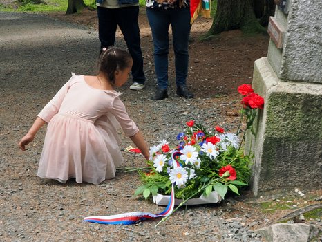 ein Mädchen legt Blumen nieder