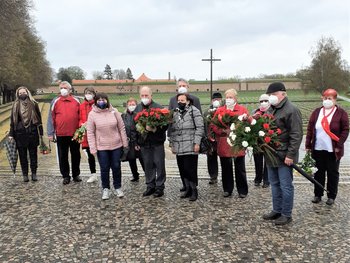GenossInnen der KSČM mit Blumen und Gebinden vor der Gedenkstätte