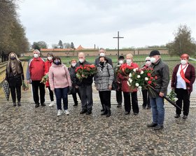GenossInnen der KSČM mit Blumen und Gebinden vor der Gedenkstätte