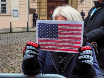 Eine Teilnehmerin der Kundgebung zeigt eine US-Flagge, auf der viele der von den USA geführten Kriege vermerkt sind