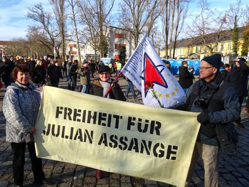GenossInnen mit dem Plakat: „Freiheit für Julian Assange“